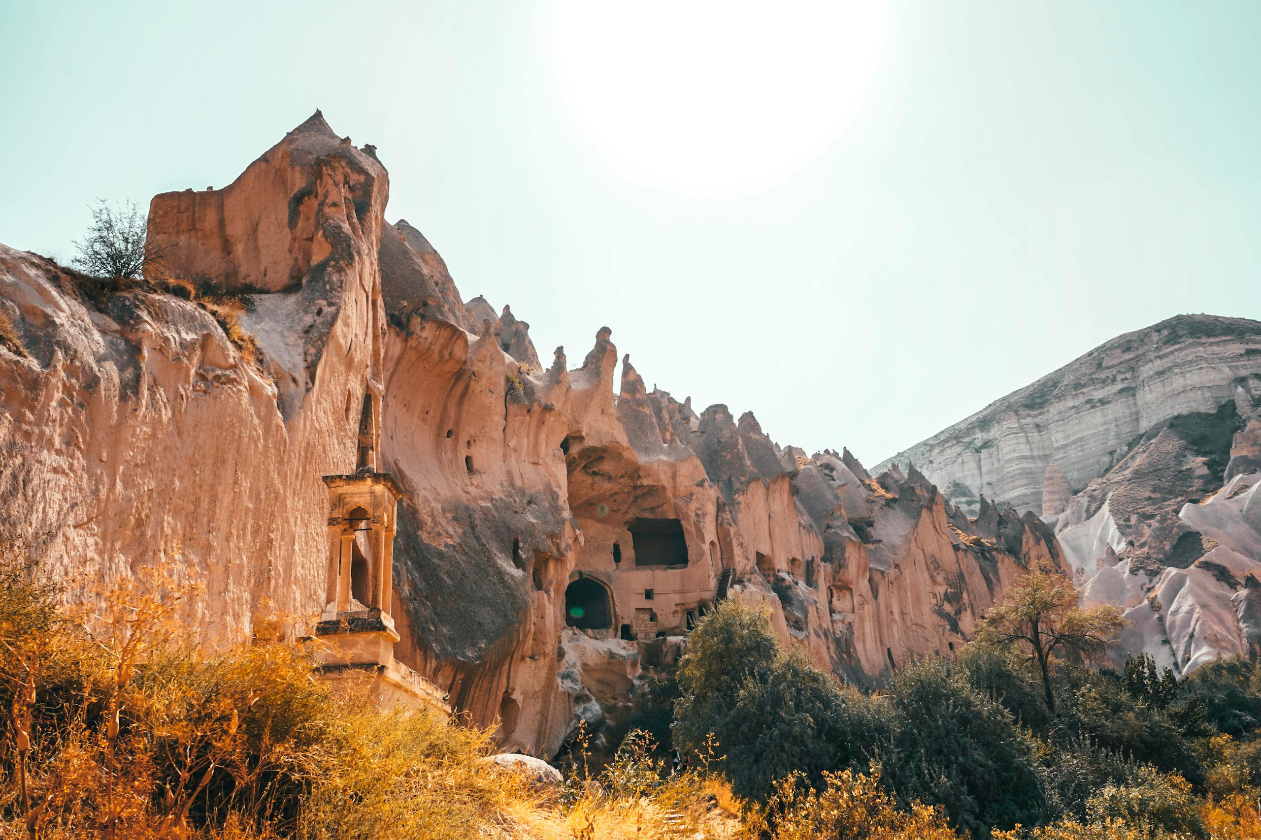 Explore the ancient rock formations of Cappadocia, Turkey, under a bright sky.